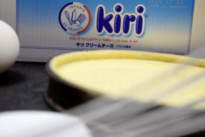 「IMPORTE DE FRANCE」のロゴが入ったキリ クリームチーズ（ベル社／フランス産）のパッケージと、手前に置かれたタルト型。型の中には滑らかなクリームチーズのフィリングが均一に広げられている